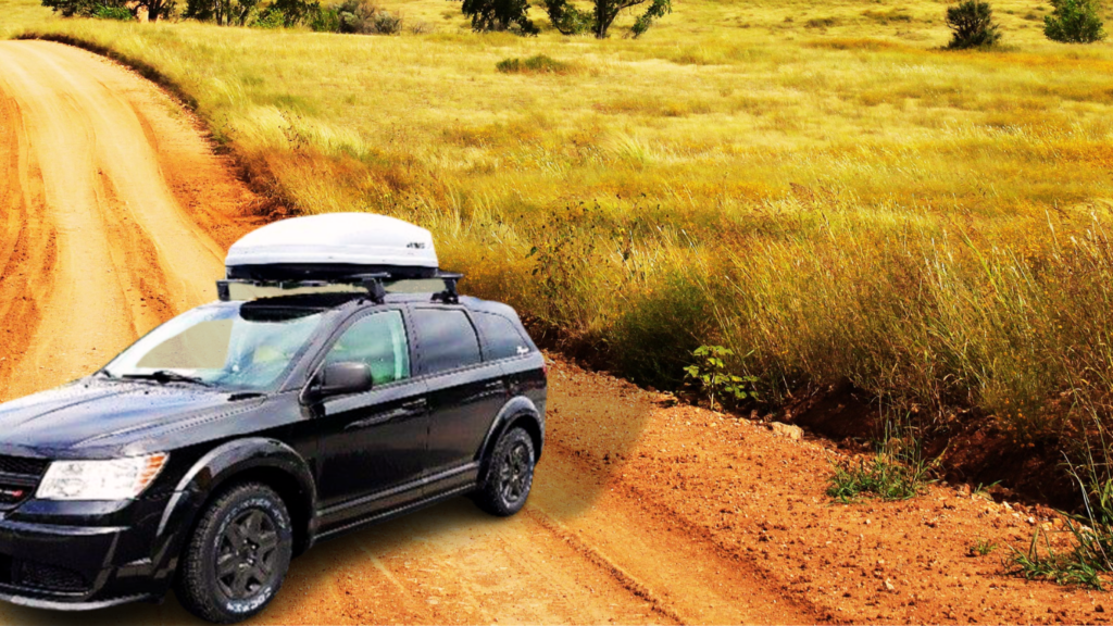 dodge journey with white cargo box on dirt road