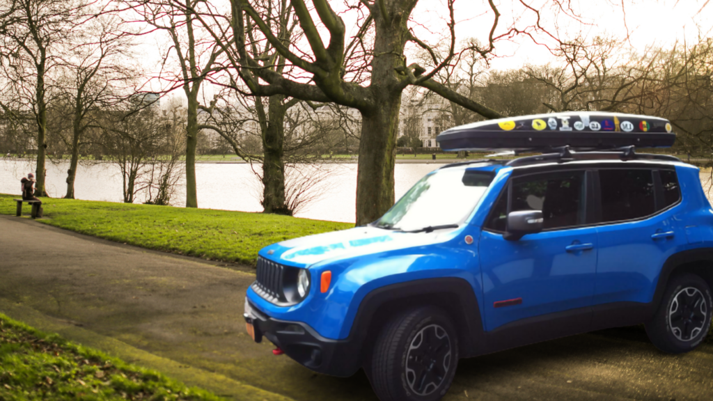 I drive my jeep renegade in a park with my belongings in a gray cargo box.