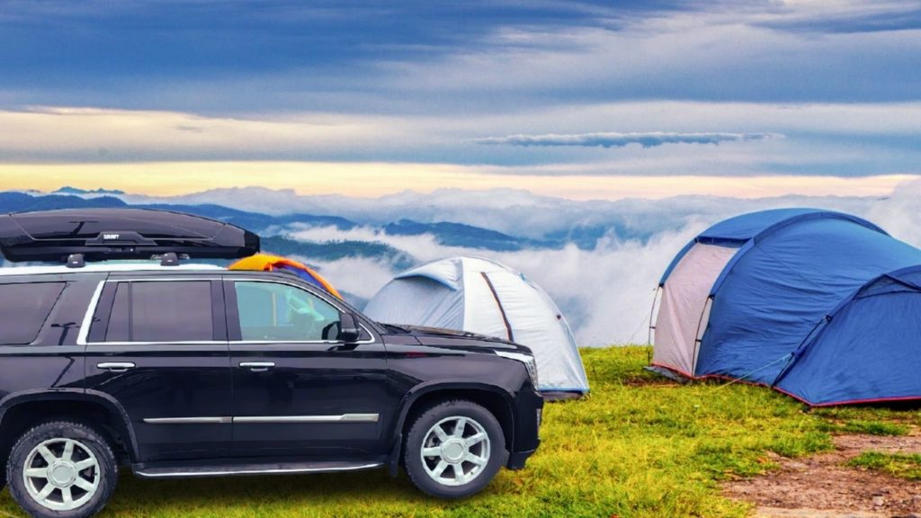 Thule Motion XL cargo box on top of Cadillac SUV in camping holiday