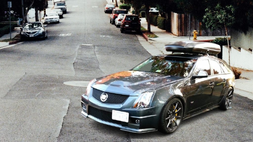 skinny sliver roof box on black Cadillac sedan on street