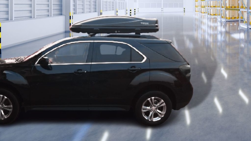 I drive my Chevrolet Equinox to my warehouse and pack my belongings into the black Thule pulse roof box.