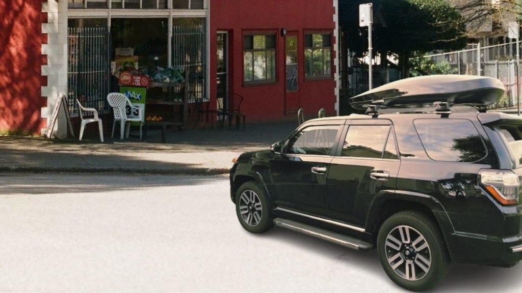 I park my black Toyota 4Runner outside a shop with rooftop luggage box for my gear and equipment