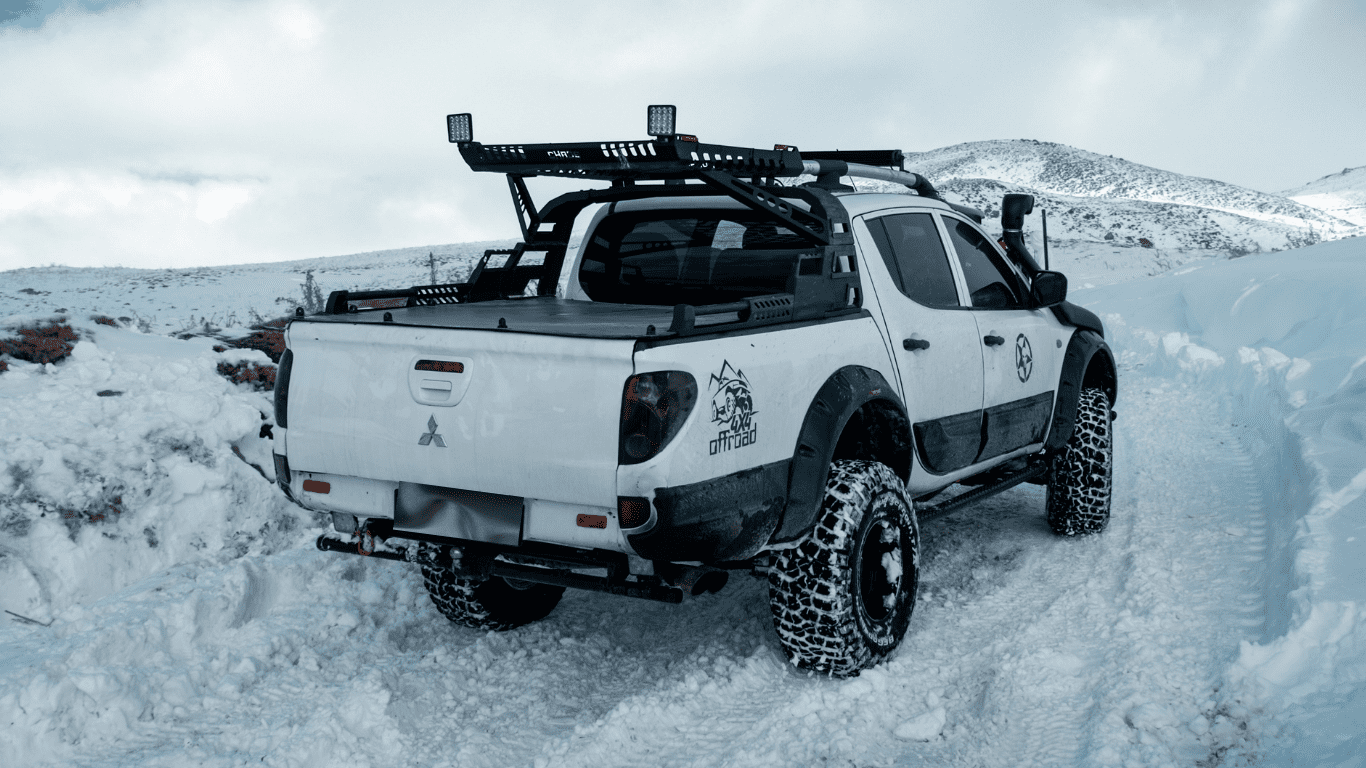 Mitsubishi Truck in snow with roof racks above the roof for carrying gear and other tools or equipment.