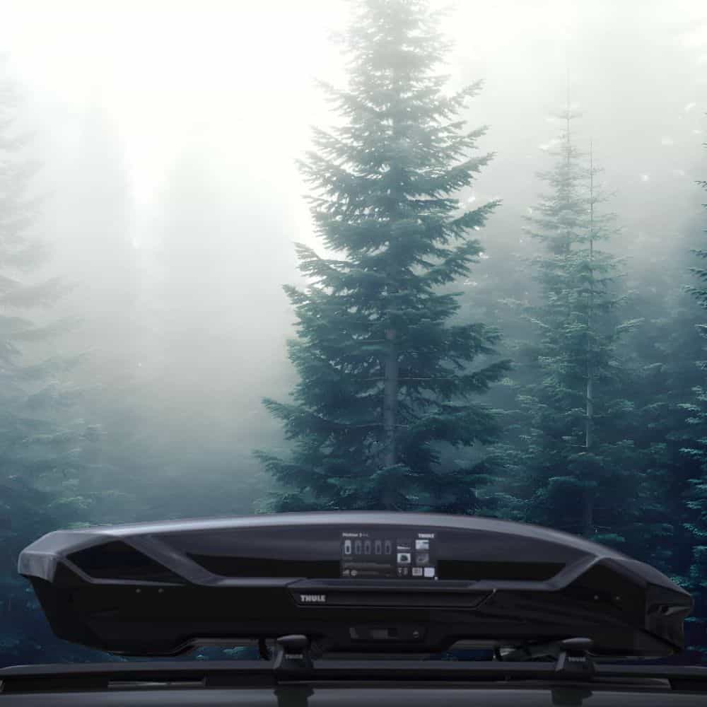 Hand pressing down on the T-handle latch to securely close the Thule Motion 3, ensuring a tight waterproof seal.