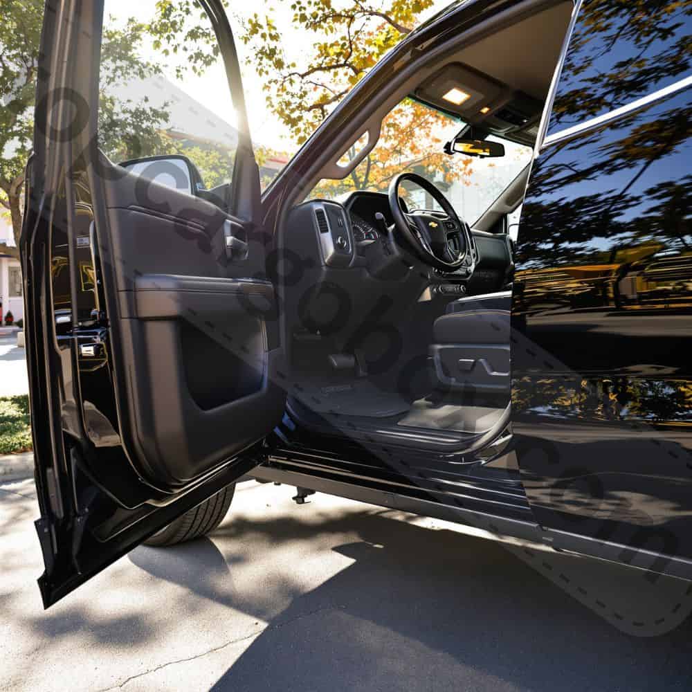 A person placing a toolbox into the Silverado's underseat storage compartment, highlighting the mat's non-interfering design.