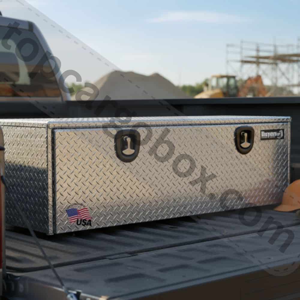 A contractor smiles confidently, easily accessing their well-organized, completely dry power tools from a spacious, rugged truck tool chest.