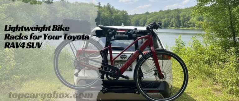A sleek, black and red Yakima HalfBack bike rack mounted securely on the trunk of a silver Toyota RAV4 in a scenic trailhead parking lot.